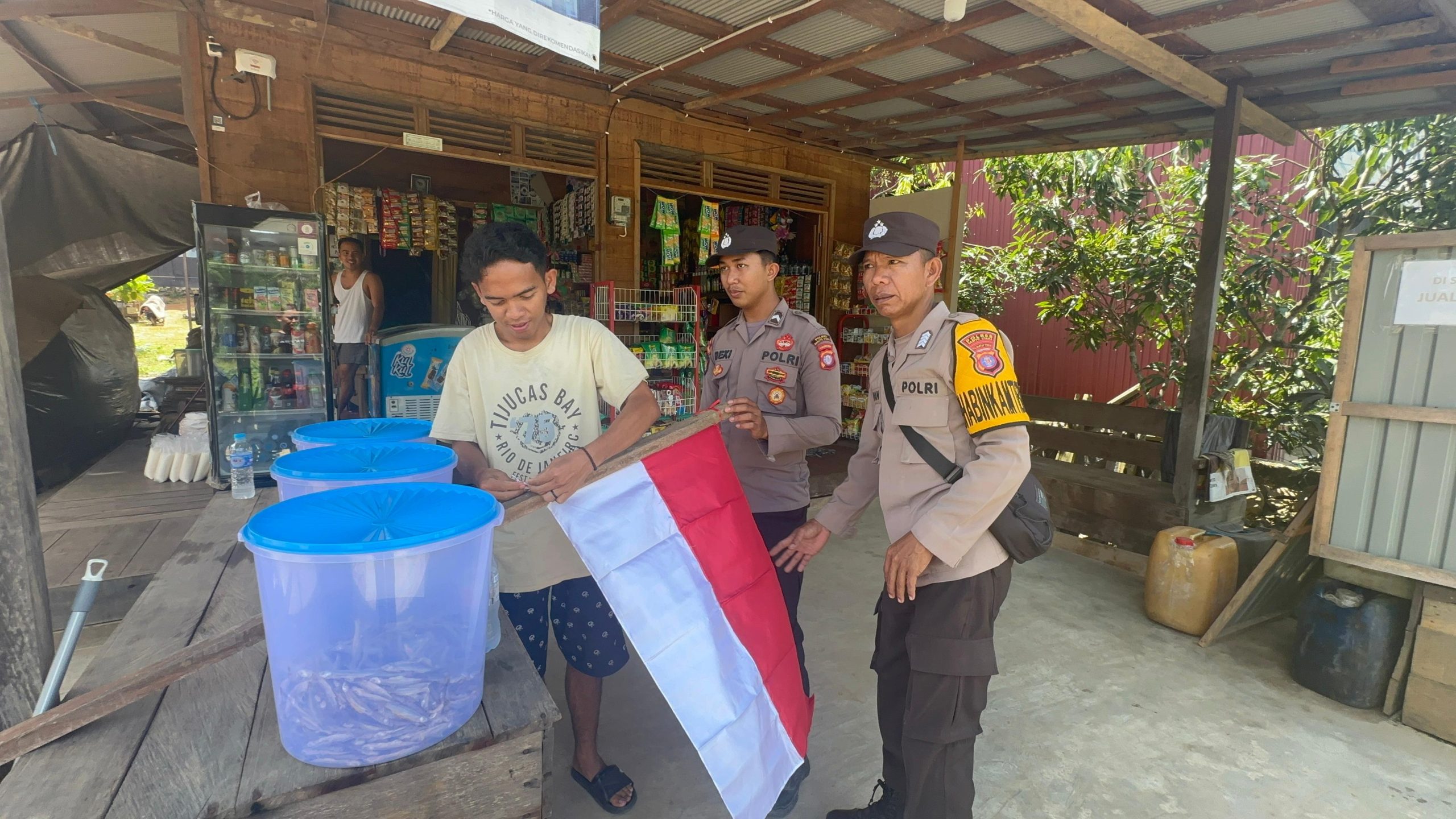 Polsek Teweh Timur Pasang Umbul-Umbul dan Bagikan Bendera Merah Putih ke Warga