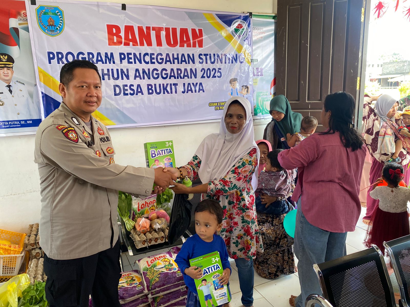Bhabinkamtibmas Desa Bukit Jaya Dampingi Penyerahan Bantuan PMT Cegah Stunting