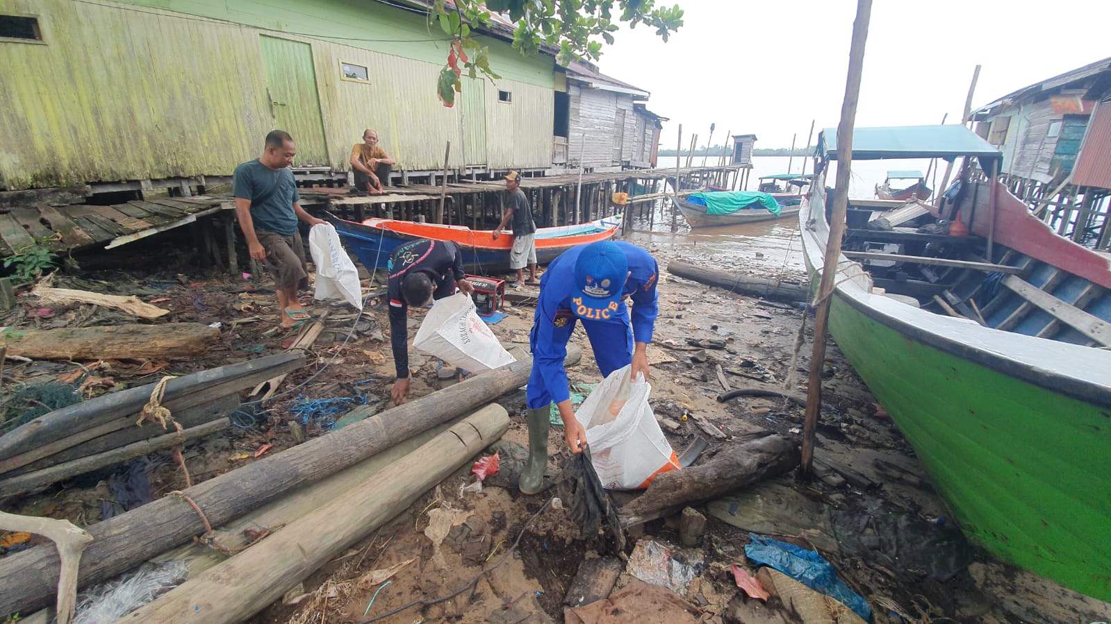 Personel Ditpolairud Polda Kalteng Mengajak Masyarakat Pegatan Bersihkan Sampah Di Persisir Pegatan Hilir Das Katingan